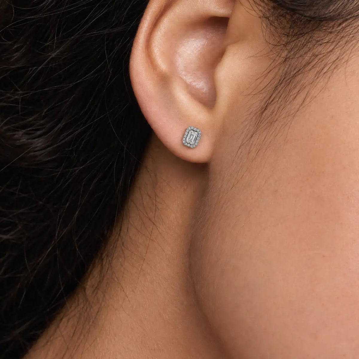 Woman wearing 1.5ct Emerald-Cut Lab Grown Diamond Halo Stud Earrings by Fortune Jewellery