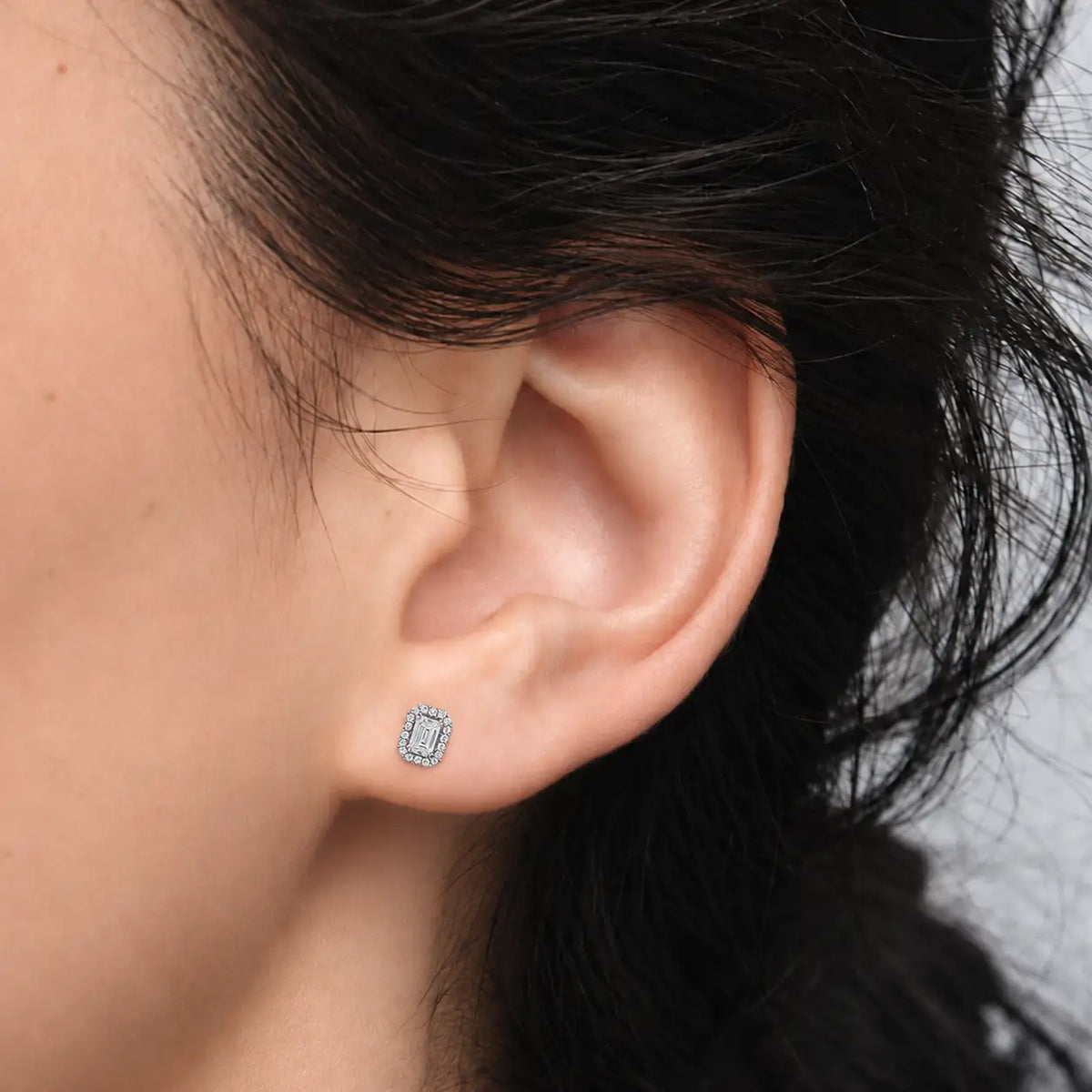 Closeup of woman wearing 1ct Emerald-Cut Lab Grown Diamond Halo Stud Earrings by Fortune Jewellery