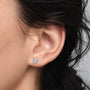 Close-up of luxurious 2ct Emerald-Cut Diamond Halo Stud Earrings worn by a woman