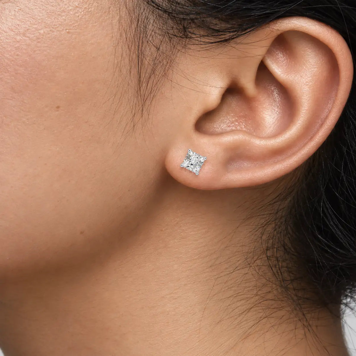 Close-up of woman wearing 8ct Cushion-Cut Lab Diamond Solitaire Stud Earrings by Fortune Jewellery