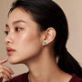 Model wearing white gold may birthstone green agate earrings with diamonds