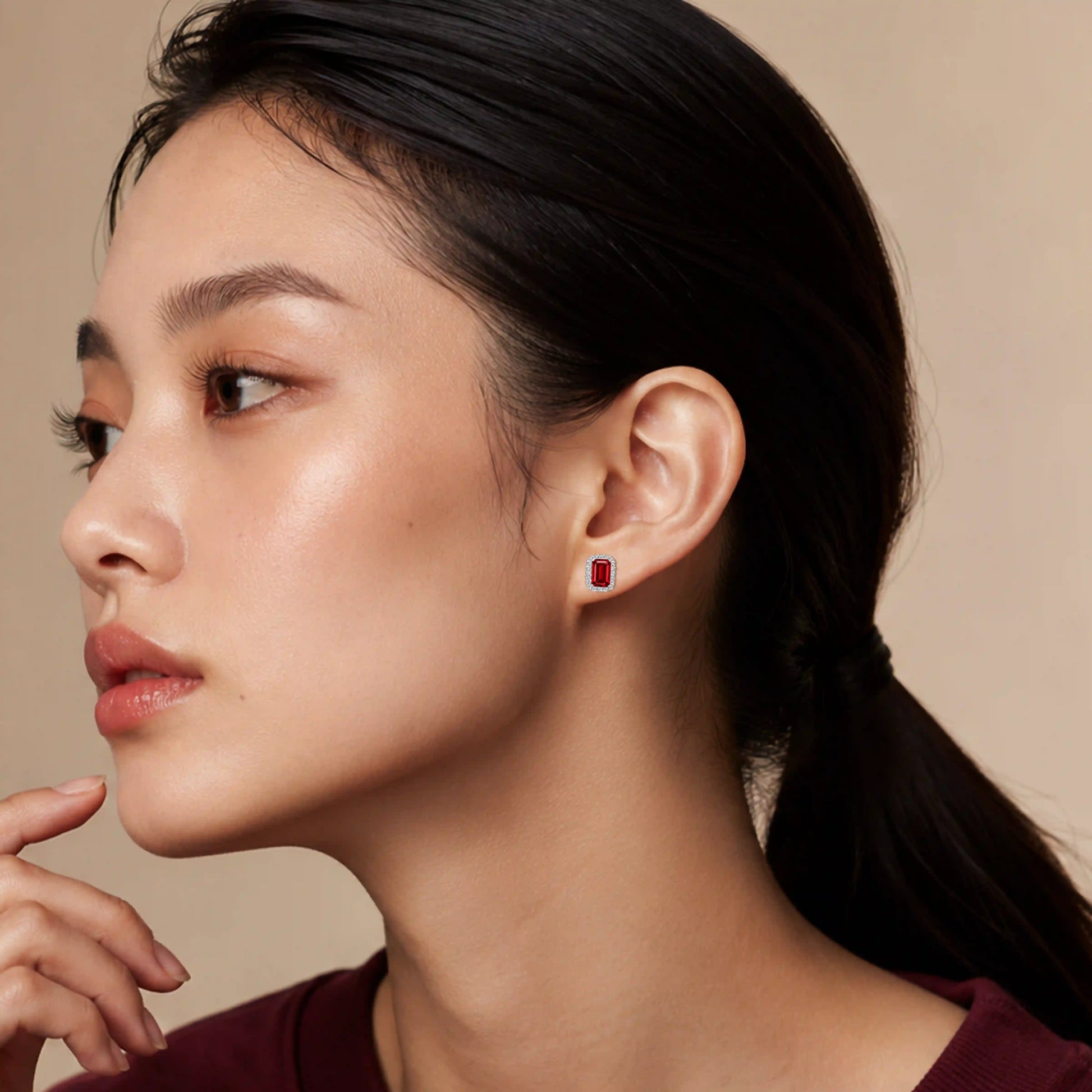 Model wearing white gold july birthstone opaque ruby earrings with diamonds