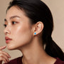 Model wearing yellow gold unique december birthstone turquoise earrings with diamonds