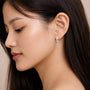 Woman wearing 10mm April Birthstone Hoops With Topaz Drops by Fortune