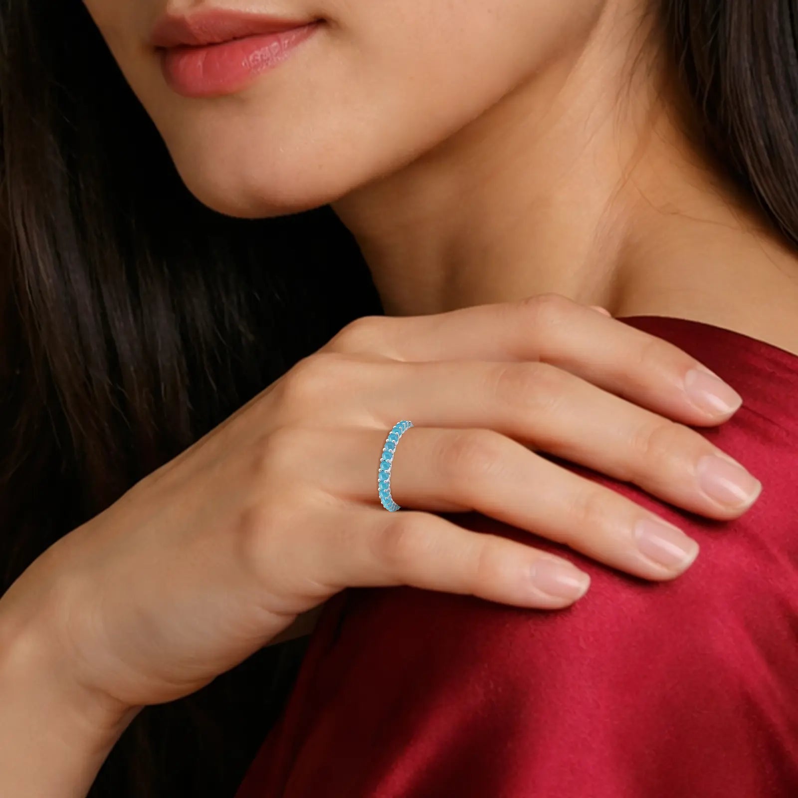 Close-up of a woman's hand wearing a December Birthstone Half Eternity Turquoise Ring